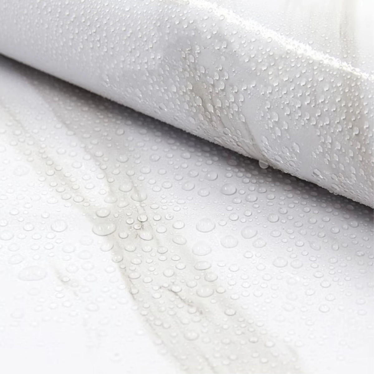 Close-up of white marble peel-and-stick wallpaper showing water droplets on a surface.