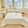 A floral quilted bedspread with a dust-proof cover is displayed on a bed in a bright room.