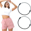 A woman models a white shirt and pink shorts while demonstrating adjustable tuck bands for clothing.