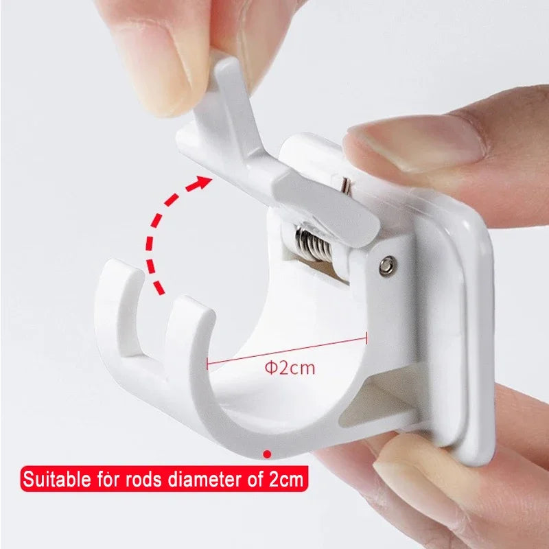 A hand is holding a white adhesive curtain rod hook clamp designed for rods with a 2cm diameter.