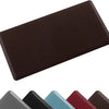 A dark brown anti-fatigue standing mat shown from above, with several colored mats in the foreground.