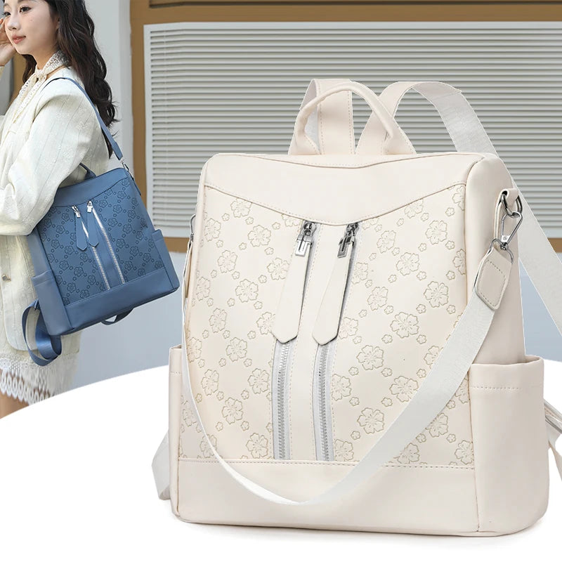 A beige leather backpack with light floral pattern and silver zippers is shown next to a woman.