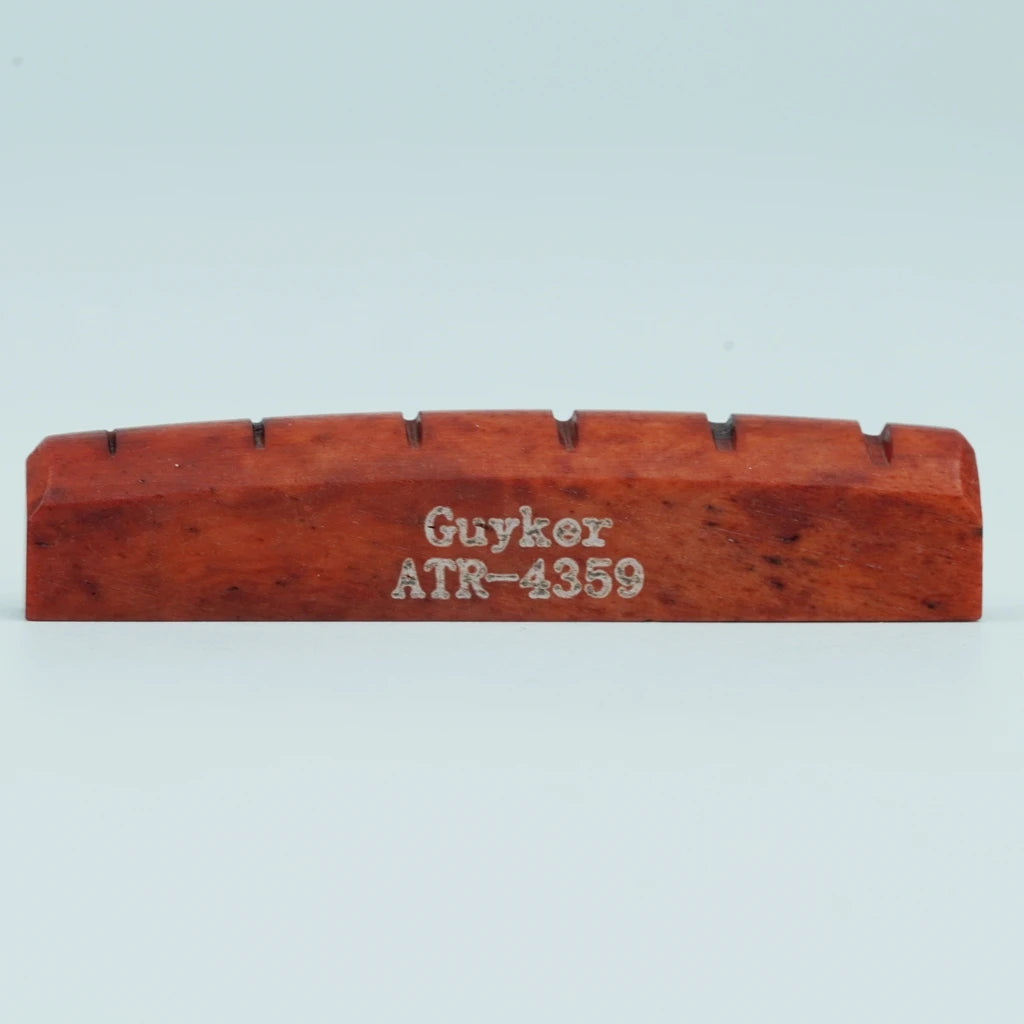 A wooden acoustic guitar bridge saddle with the name Guyker ATR-4359 engraved on it.