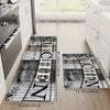 A rectangular kitchen mat featuring a distressed wood grain design with black and white lettering on a light wooden floor.