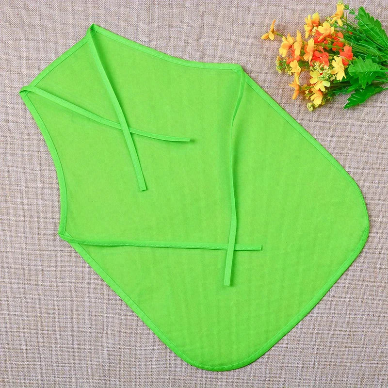 A bright lime green non-woven fabric craft apron folded and displayed on a beige cloth with orange flowers.