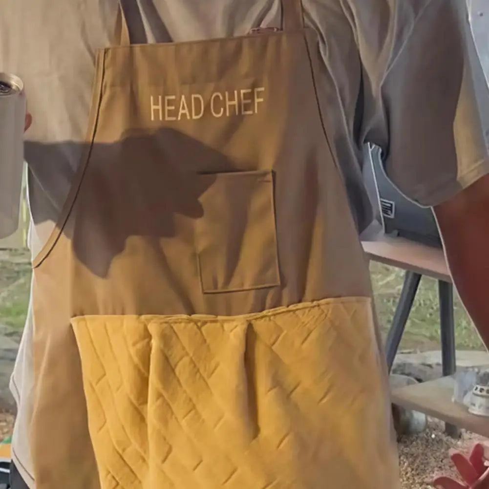 A tan chef apron with the text HEAD CHEF and a yellow quilted pocket on the front.