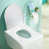 A white portable disposable toilet seat cover is mounted on a light blue wall, with a roll of toilet paper nearby.