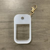 Clear silicone protective case for a hand sanitizer spray attached to a gold keyring