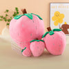 Pink strawberry plush throw pillow with green leaves and a brown stem
