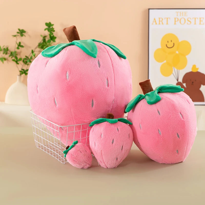 Pink strawberry plush throw pillow with green leaves and a brown stem