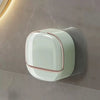 A modern, translucent white soap holder with a pink accent is mounted on a wall.