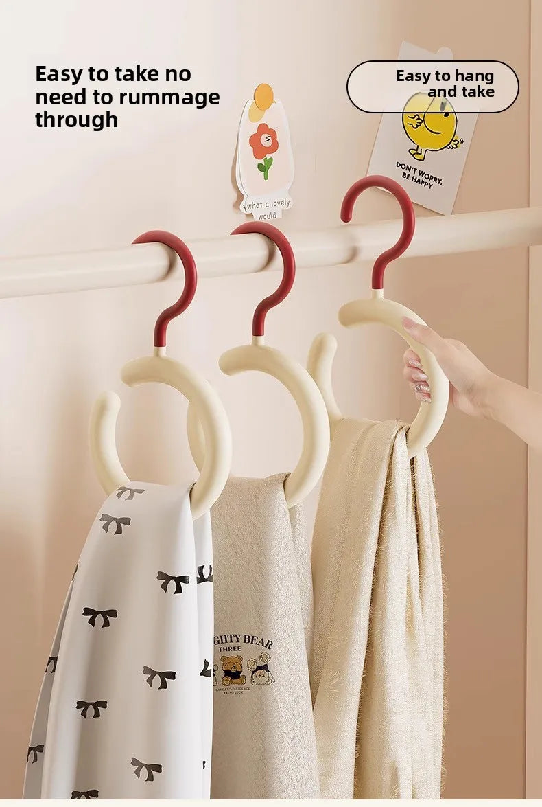 A white Nordic wall-mounted hat and scarf organizer hook displaying various light-colored scarves on a wooden rack.