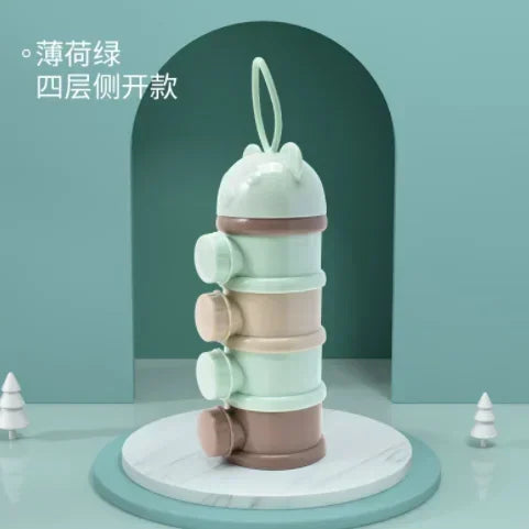 A stack of four light green and pink bear-shaped baby food storage containers on a white marble base.