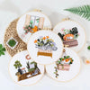 A collection of round embroidery hoops featuring floral and cat designs on white fabric.