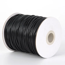 A spool of black waxed cord rope for jewelry making and DIY projects.