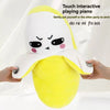 A yellow fruit-shaped plush toy with a face is being gently patted by a hand.