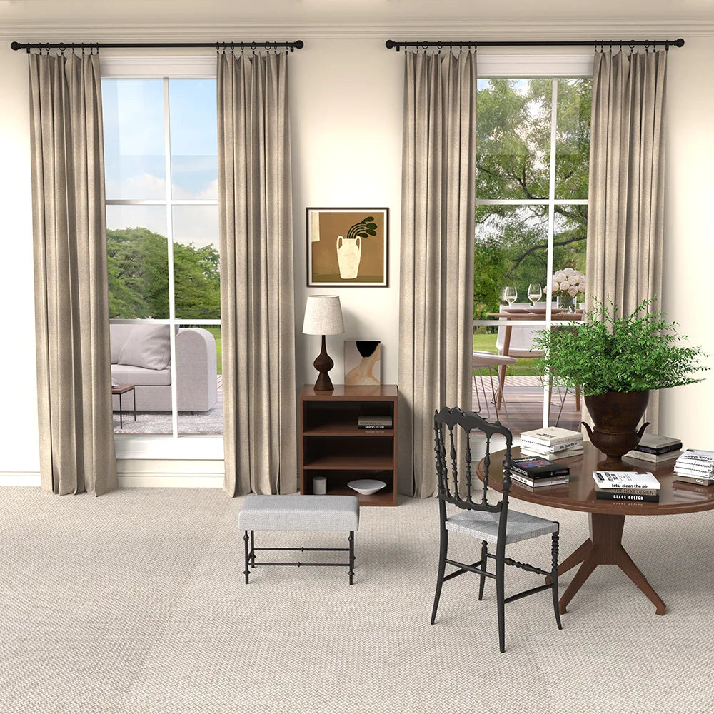A set of classic iron curtain rods with ball finials in a neutral tone displayed next to a window.