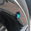 A close-up view of a tire valve stem with an aluminum alloy dice design cap installed.