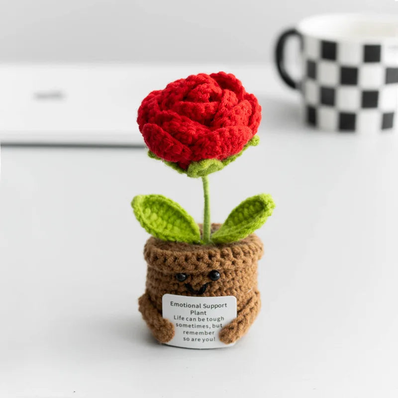 Handmade crochet plant decoration featuring a red rose and green leaves in a brown pot