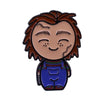An enamel pin depicting Chucky, a horror movie doll with brown hair and stitched features, wearing a blue shirt.