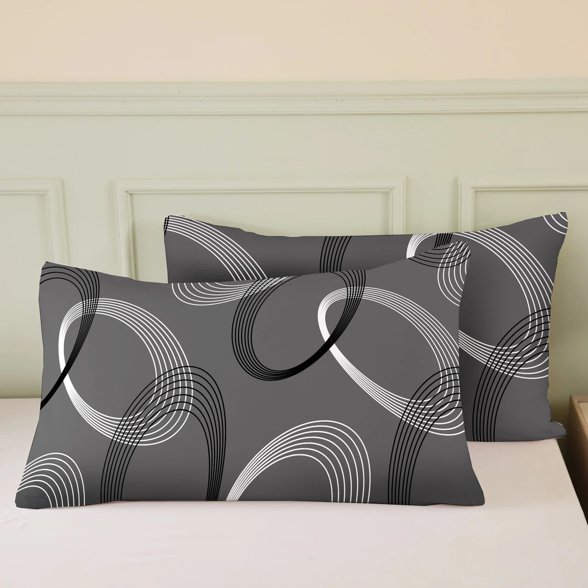 A set of three geometric print pillow covers and a duvet cover in shades of gray and white.