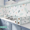 Light blue and green botanical patterned self-adhesive kitchen splashback sticker wallpaper on cabinetry.