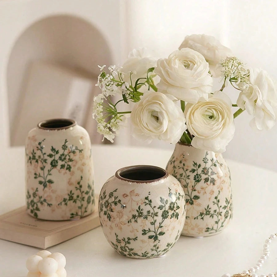 Eine Ansammlung handgefertigter Eisgecrackter Keramikvasen in Weiß- und Grüntönen mit weißen Rosen.
