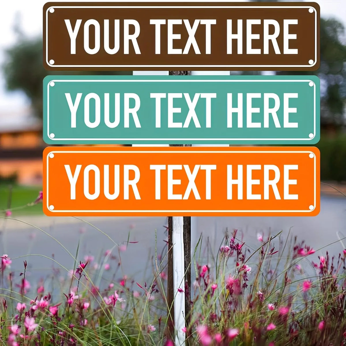 Three rectangular signs with brown, teal, and orange backgrounds displaying placeholder text mounted on a metal post in a gar