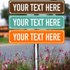 Three rectangular signs with brown, teal, and orange backgrounds displaying placeholder text mounted on a metal post in a gar
