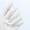 A hand wearing a white disposable nitrile glove holds a clear circular area showing the texture of the glove.