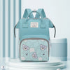 A light blue bear print waterproof diaper backpack displayed on a white stand against a light blue background.