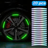 A close-up of a car wheel with bright green reflective stickers installed on the rim.