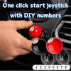 A hand is shown placing numbered billiard balls onto a metal push-to-start joystick cover.