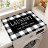A laundry room featuring a white washing machine with a black and white plaid top protector mat on the top surface.