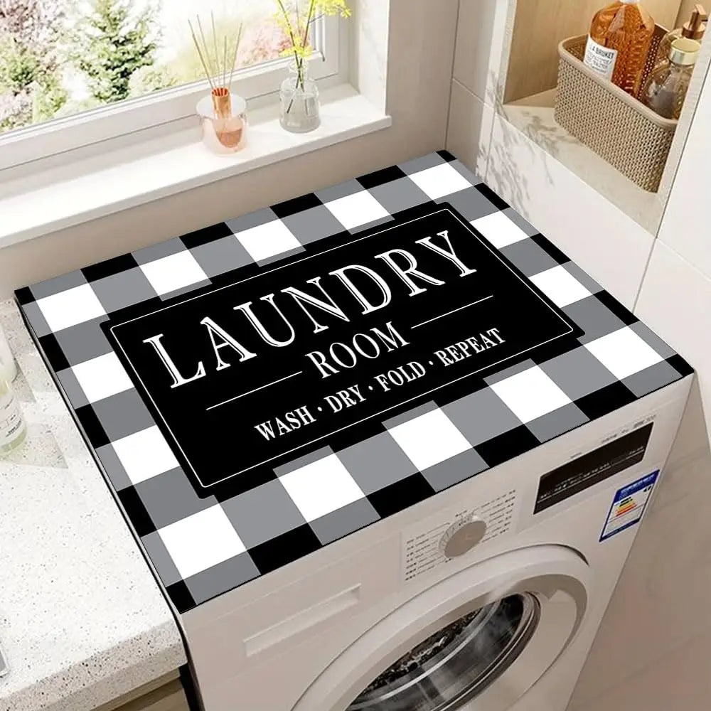 A laundry room featuring a white washing machine with a black and white plaid top protector mat on the top surface.