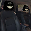 A pair of black car headrest covers featuring a creepy, grinning face design.