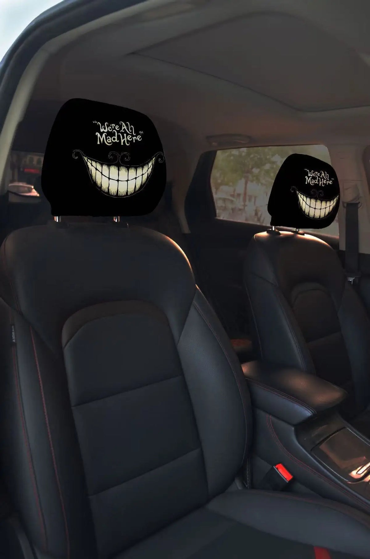 A pair of black car headrest covers featuring a creepy, grinning face design.