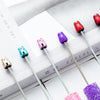 A collection of ten kawaii beaded ballpoint pens in various colors, including red, purple, and silver, resting on a white bac