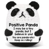 A white and black panda crochet doll with a positive message card that says I may be a tiny panda but I believe in you