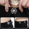 Close-up of an adjustable silver flower waist clip fastened onto a black garment.
