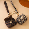 A leopard print PU leather keychain mini wallet with a brown leather strap and gold hardware.