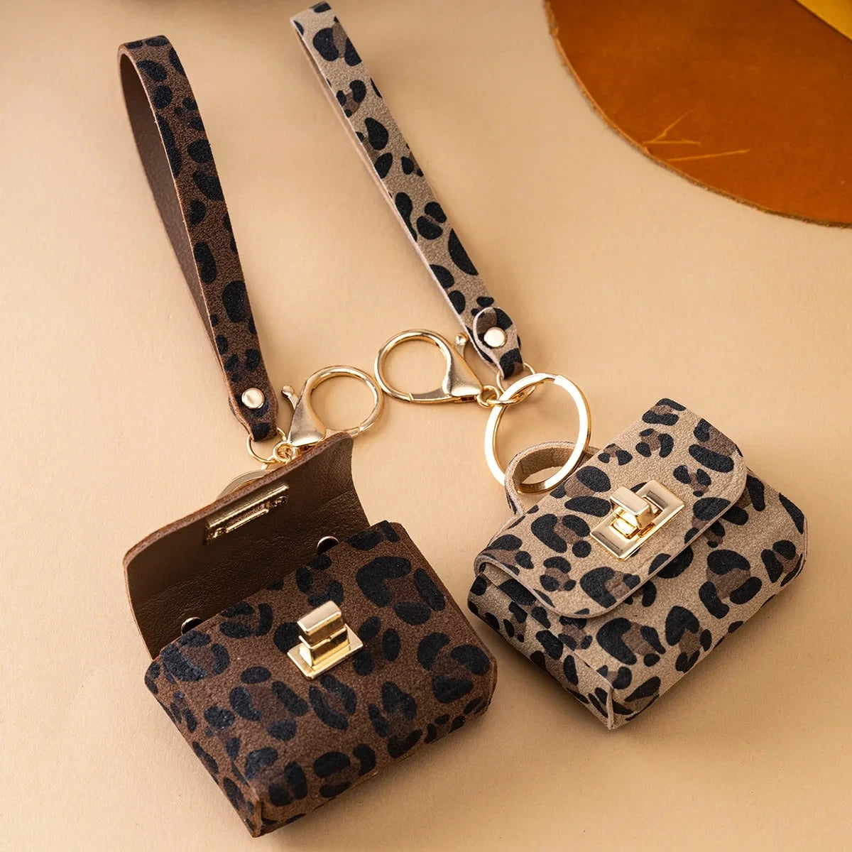 A leopard print PU leather keychain mini wallet with a brown leather strap and gold hardware.