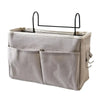 A light gray hanging storage organizer with two cotton pockets and a black metal hanger.