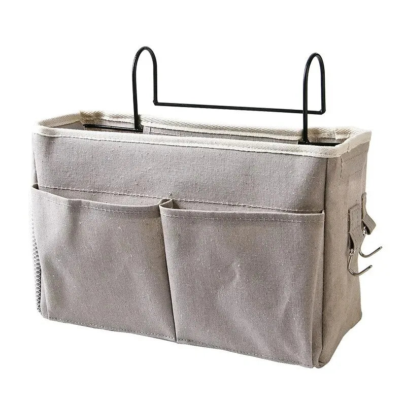 A light gray hanging storage organizer with two cotton pockets and a black metal hanger.