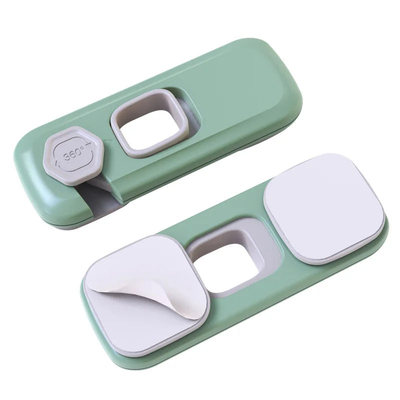 A light green child safety cabinet lock device with a removable white cover and a 360-degree indicator.