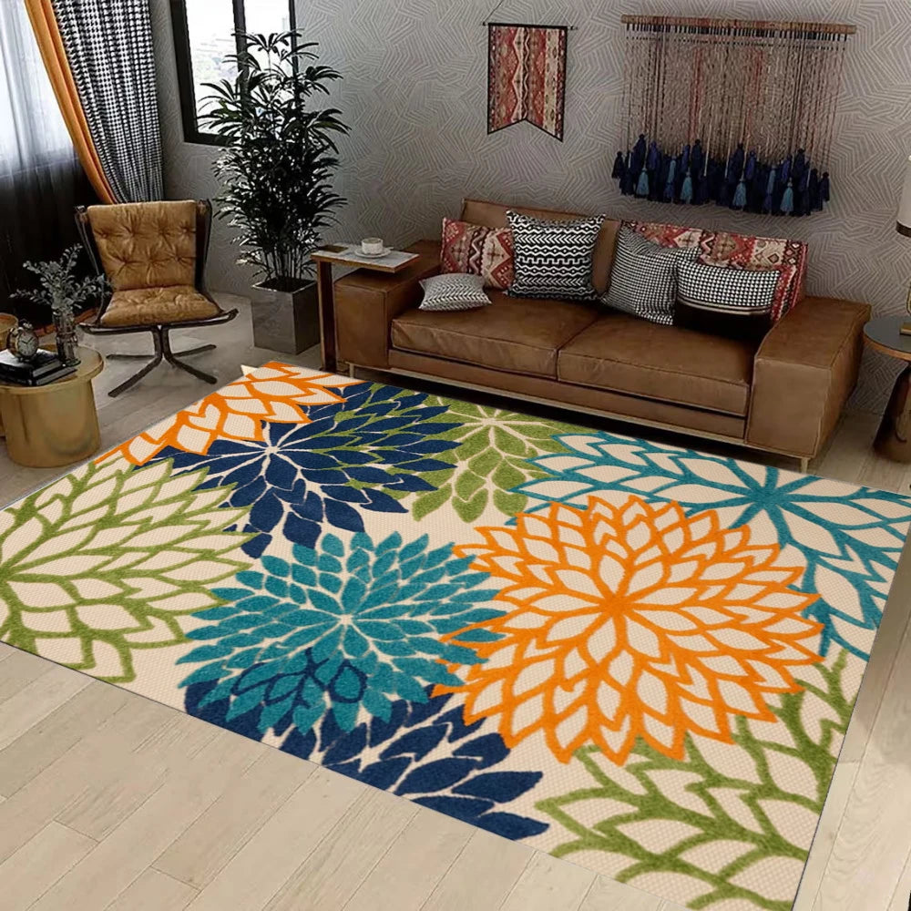 A colorful outdoor area rug featuring a tropical botanical pattern with shades of teal, orange, and green.