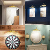 A collection of interior lighting fixtures, including a picture light above a canvas and a decorative wall sconce with a roun