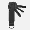 A black minimalist aluminum key organizer with a handle and multiple slots for holding keys.