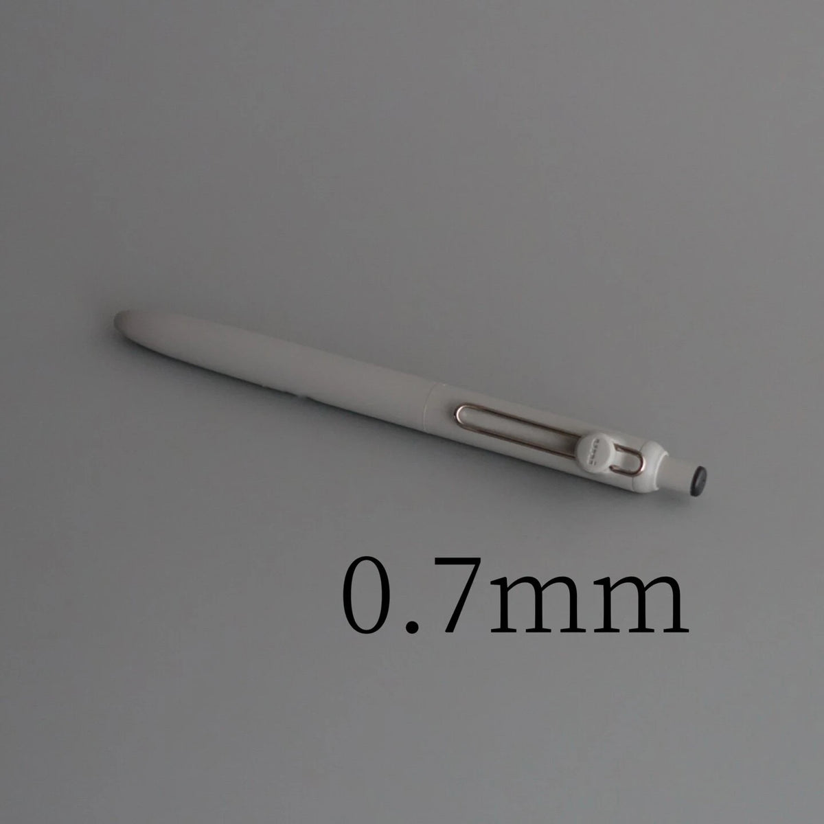 A close-up view of a white Uni ZENTO Quick-Dry Gel Pen, showing its slender body and tip.