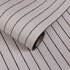 Roll of 3D grille pattern peel-and-stick wallpaper showing vertical black and white stripes.